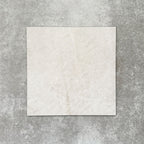 Close-up of Divine Taj Mahal matt marble-effect tile in a 30cm x 30cm format, featuring soft ivory and warm cream tones with subtle natural stone-inspired movement. The understated marble effect creates a timeless and elegant finish, making it ideal for chequerboard floor designs, bathrooms, hallways and sophisticated interior spaces.