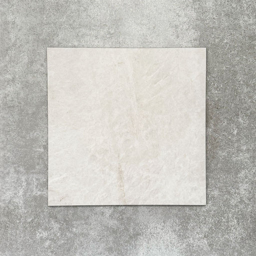 Close-up of Divine Taj Mahal matt marble-effect tile in a 30cm x 30cm format, featuring soft ivory and warm cream tones with subtle natural stone-inspired movement. The understated marble effect creates a timeless and elegant finish, making it ideal for chequerboard floor designs, bathrooms, hallways and sophisticated interior spaces.