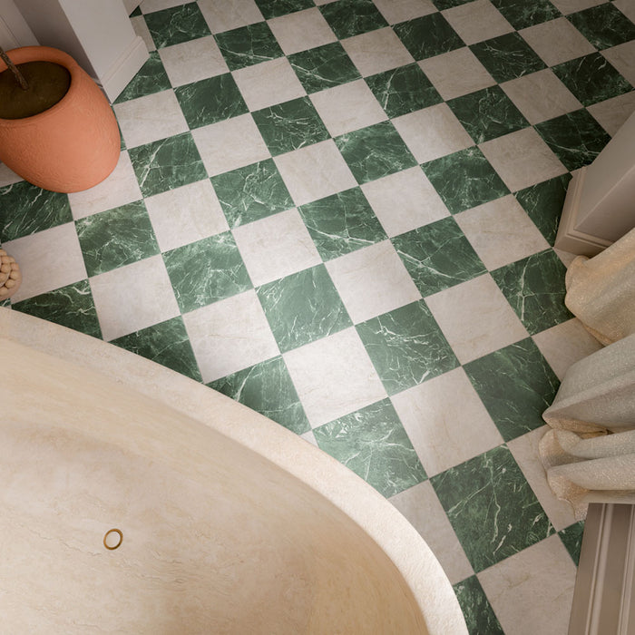 Bathroom featuring Divine Verde Green marble-effect chequerboard tiles, pairing rich green veining with soft ivory tones for a timeless floor design. Combined with deep green walls, brass accents and natural textures, the space feels elegant, luxurious and full of character.