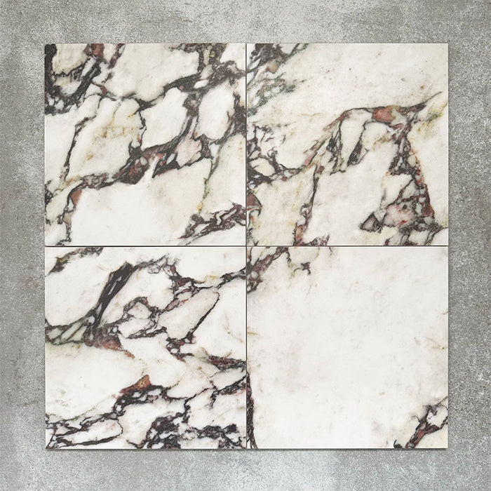 Close-up of Divine Viola matt marble-effect tile in a 30cm x 30cm format, featuring a crisp white background with dramatic burgundy, plum and charcoal veining. Inspired by luxurious natural marble, the striking contrast and rich colour variation make it ideal for statement chequerboard floors, feature areas and elegant interior schemes.
