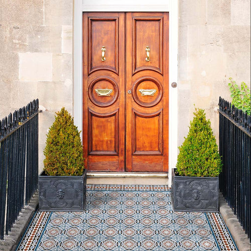 Front doorway featuring Imperial Victorian Blue Mini Border Tiles, 15x15cm porcelain tiles with a classic Victorian-inspired border pattern, framing a decorative tiled entrance beneath a traditional wooden door.