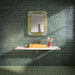 Bathroom featuring Dordogne Green Pines 7.5x15cm rustic gloss wall tiles, showcasing rich green tones with handmade-style shade variation, paired with a white floating vanity, mustard yellow basin, brass fittings, ornate mirror and patterned green floor tiles.