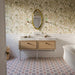 Bathroom featuring Dordogne White Blanca Bullnose Pencil Border Tiles 3cm x 20cm, creating a neat finishing detail above white wall tiles, paired with patterned floor tiles, botanical wallpaper, a marble vanity and classic fixtures.