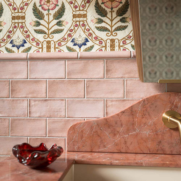 Dordogne Pink Dust 7.5cm x 15cm rustic effect gloss wall tiles, featuring soft pink tonal variation in a classic brick layout, finished with coordinating pink trim, floral pattern and warm brass details.