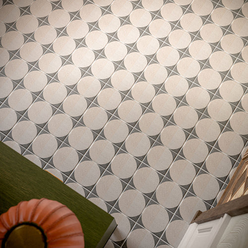 Hallway featuring Eclipse Lunar 20x20cm terrazzo-effect patterned floor tiles, styled with a statement green sideboard, colourful floral arrangement, decorative mirrors and elegant contemporary interiors with warm neutral tones.