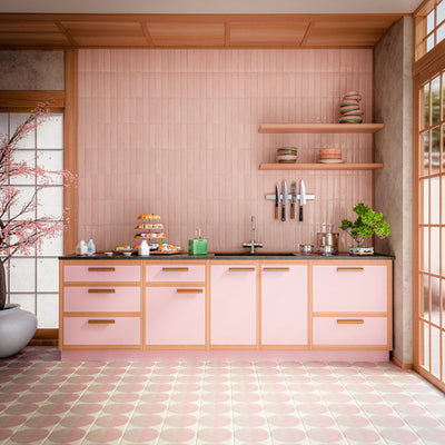 Eclipse Rosa 20cm x 20cm terrazzo effect decor tiles, featuring a soft pink and cream geometric pattern across the kitchen floor, paired with blush cabinetry, pink wall tiles and warm wood details.