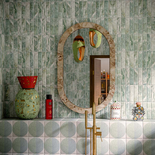Bathroom featuring Eclipse Salvia 20x20cm terrazzo-effect patterned wall and floor tiles, styled with a freestanding stone bath, green marble-effect brick tiles, brushed brass fixtures and botanical-inspired contemporary décor