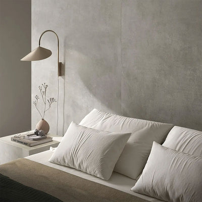 Bedroom interior featuring Etna Grey Matt 60 × 60cm porcelain wall tiles, styled with soft neutral bedding, a minimalist bedside table, and warm lighting for a calm, contemporary, restful space.