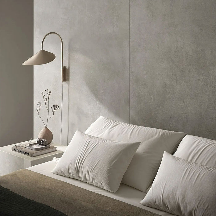 Bedroom interior featuring Etna Grey Matt 60 × 60cm porcelain wall tiles, styled with soft neutral bedding, a minimalist bedside table, and warm lighting for a calm, contemporary, restful space.