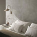 Bedroom interior featuring Etna Grey Matt 60 × 60cm porcelain wall tiles, styled with soft neutral bedding, a minimalist bedside table, and warm lighting for a calm, contemporary, restful space.