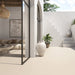 Outdoor patio featuring Etna Marfil Matt 60 × 120cm porcelain floor tiles, styled with soft neutral tones, Mediterranean-inspired architecture, large planters, and natural light for a calm, contemporary indoor-outdoor living space.