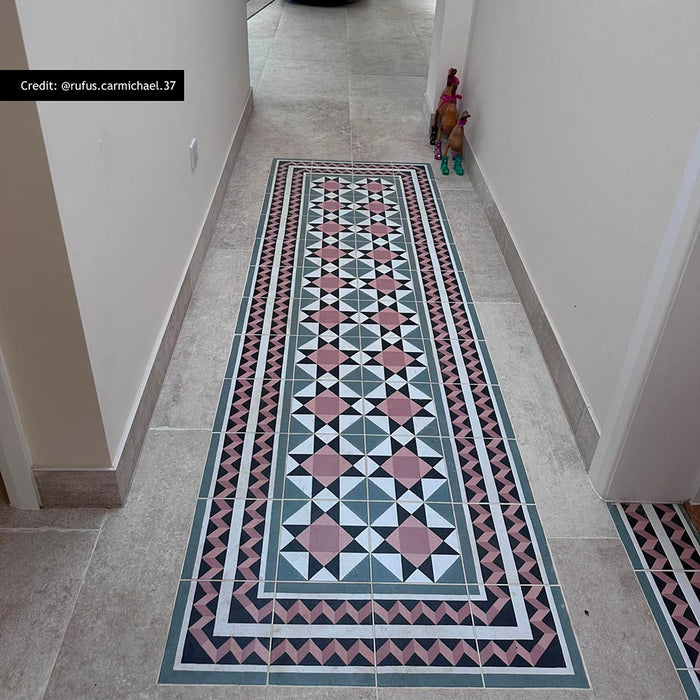 Hallway featuring Farnham Manor Victorian style floor tiles in 20cm x 20cm. Pink, black and green geometric Victorian style tiles create a striking runner bordered with matching decorative tiles, framed by large stone effect porcelain floor tiles for a timeless entrance.