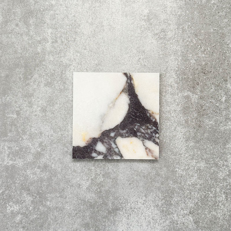 Fayrouz Calacatta Viola honed natural marble tile in a 15.2cm x 15.2cm square format, featuring a creamy white background with bold purple veining and subtle warm gold tones, creating a luxurious and timeless natural stone finish.