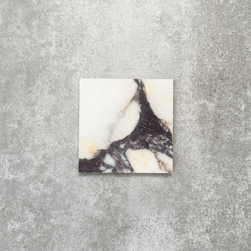 Fayrouz Calacatta Viola honed natural marble tile in a 15.2cm x 15.2cm square format, featuring a creamy white background with bold purple veining and subtle warm gold tones, creating a luxurious and timeless natural stone finish.