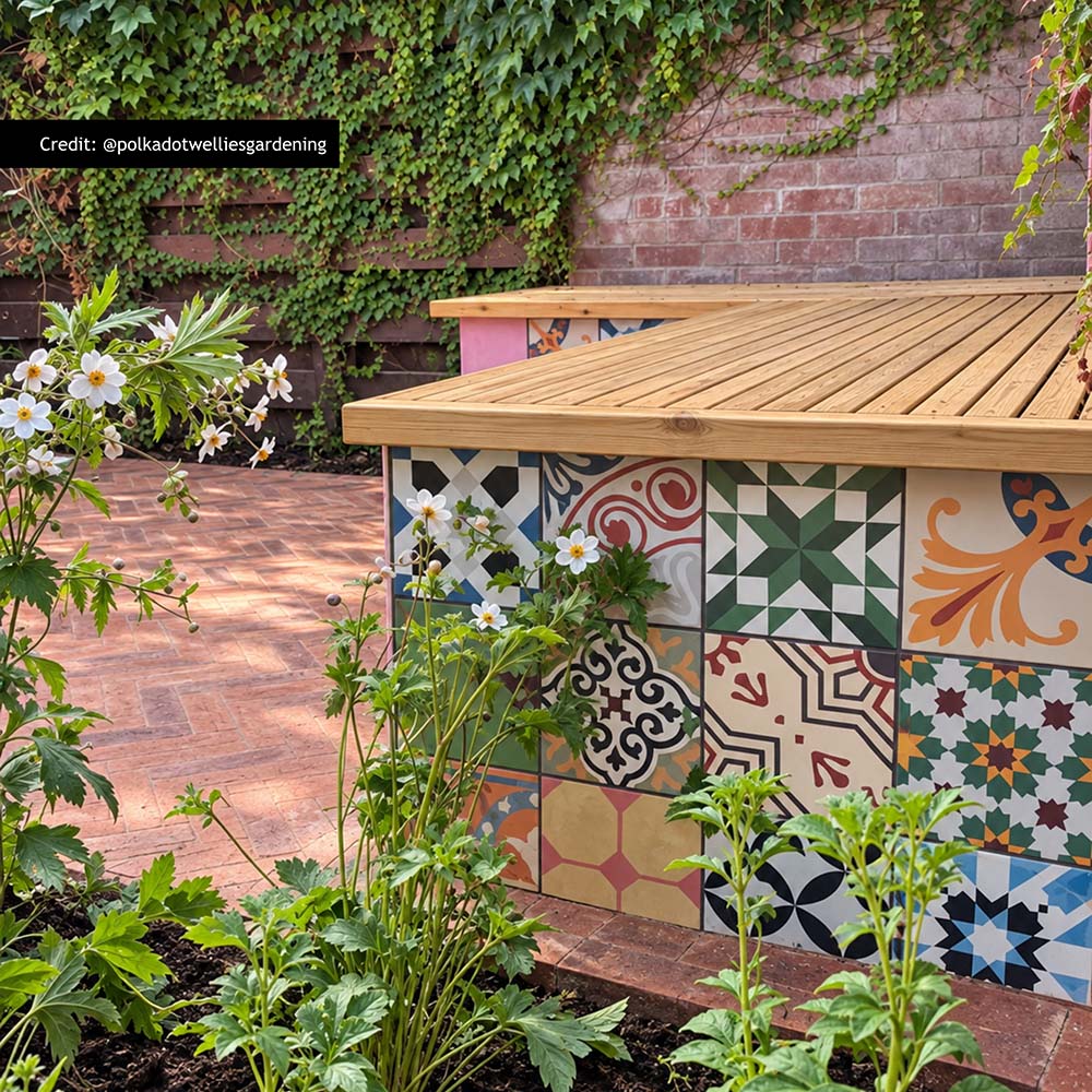 Fayrouz Patchwork 20cm x 20cm Moroccan style tiles, bringing an eclectic mix of colour and pattern to this outdoor seating area, paired with warm herringbone paving and natural greenery.