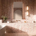 Luxury bathroom featuring Fayrouz Sylvester Pink honed natural marble tiles in 30.5cm x 61cm and matching 15.2cm x 15.2cm floor tiles. Soft pink marble wall and floor tiles with natural veining create an elegant, spa-inspired bathroom with warm brass fixtures.
