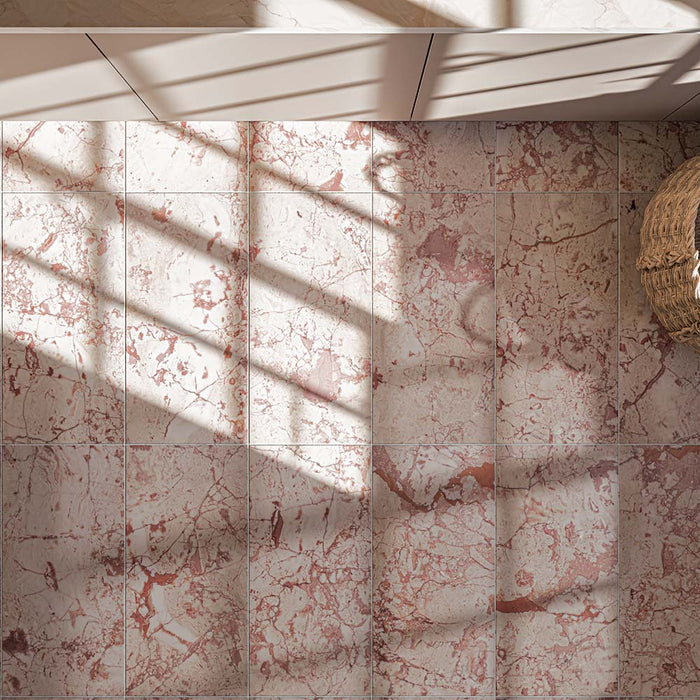 Close-up of Fayrouz Sylvester Pink 30.5cm x 61cm natural marble floor tiles, showcasing distinctive pink and rose veining across a soft cream base with natural variation between each tile.