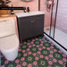 Bathroom featuring Fez Autumn 20cm x 20cm Moroccan-style floor tiles with a pink and green floral pattern, paired with blush pink metro tiles, a dark vanity unit and contemporary black shower framing.