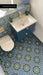 Bathroom featuring Fez Springs 20x20cm Moroccan-style patterned floor and wall tiles in deep blue and green tones, styled with a navy vanity unit, brushed brass fixtures, and contemporary décor.