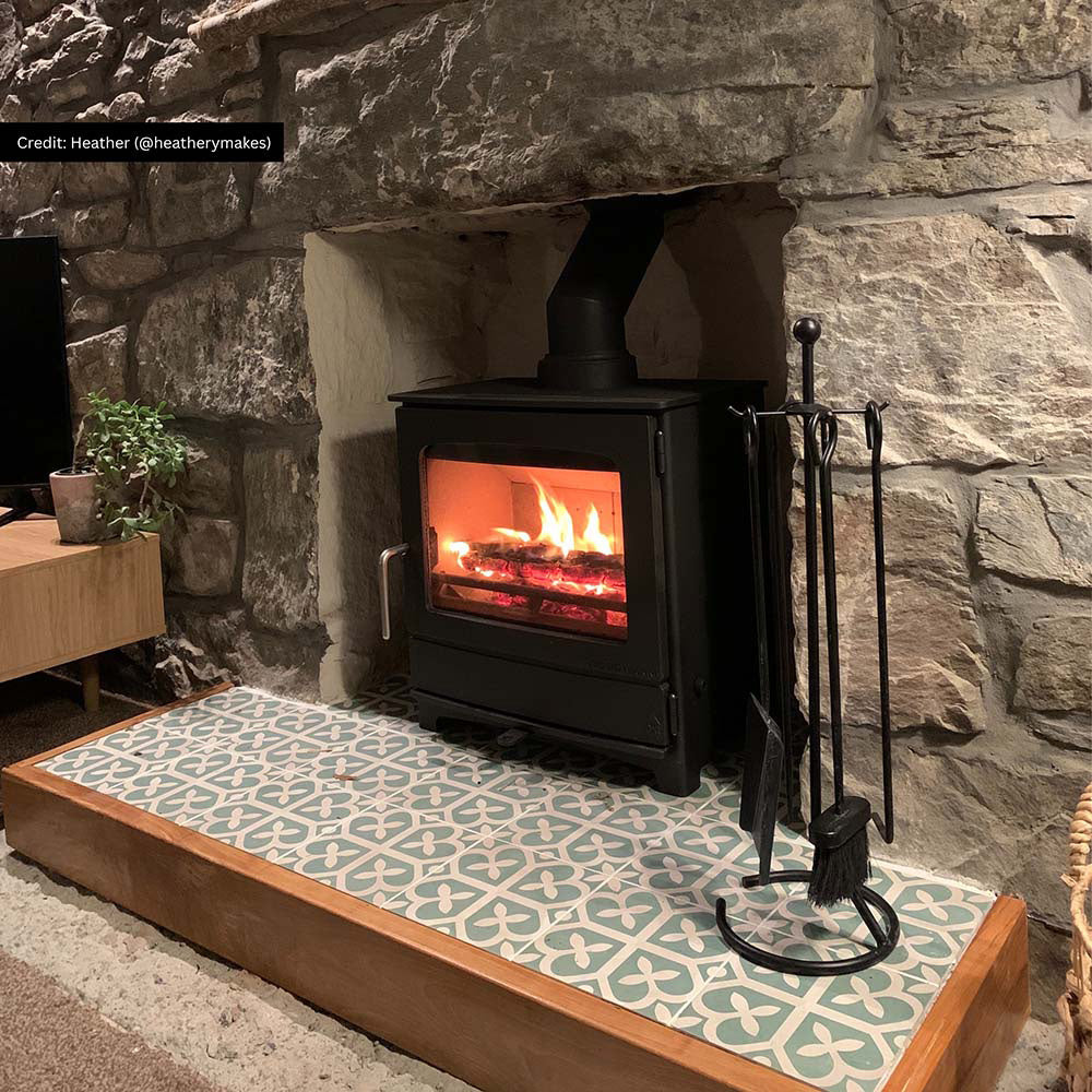 Ivy Green Victorian Moroccan style 20x20cm patterned tiles, used on a fireplace hearth to create a decorative green and white geometric feature.