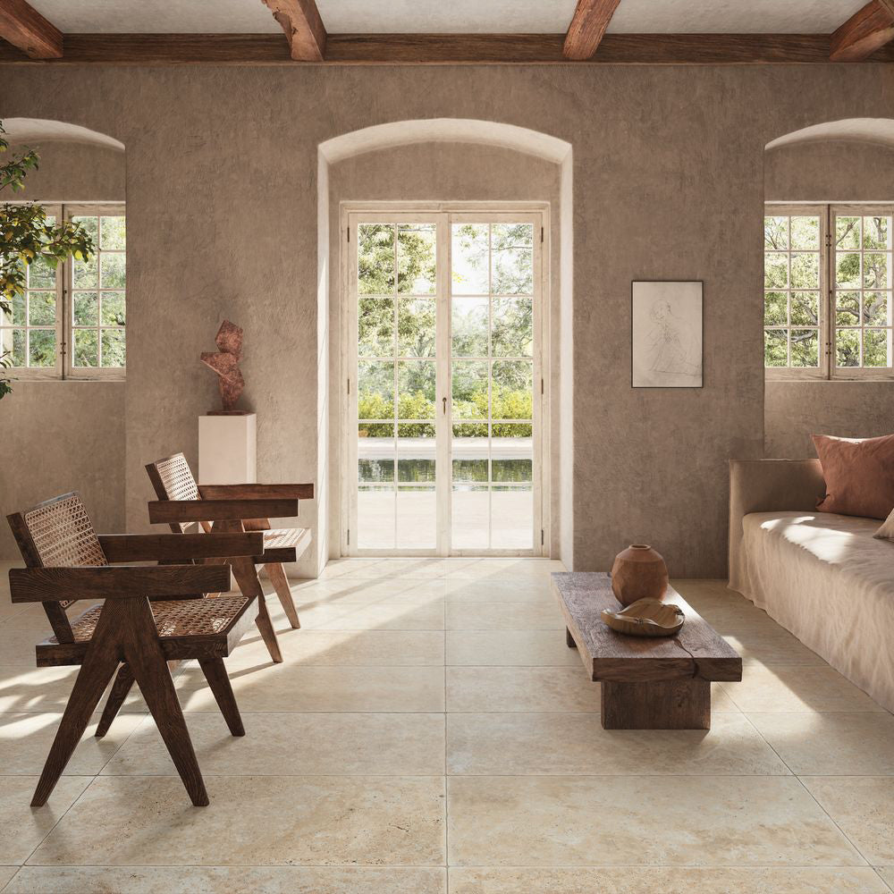 Living room featuring Flagstone Beige Tumbled Travertine 50 × 100cm porcelain floor tiles, styled with rustic wood furniture, soft neutral tones, and natural light for a warm, Mediterranean-inspired space.