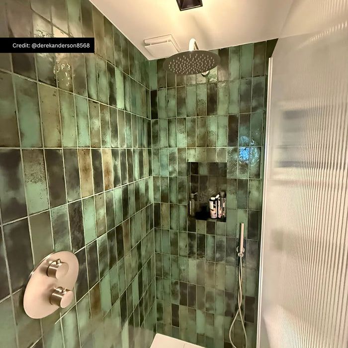 Walk-in shower featuring Foundry Bricks Jade Green Wall Tiles 6.5cm x 20cm, laid vertically with striking shade variation, paired with brushed stainless steel shower fittings, a recessed storage niche and a fluted glass shower screen.