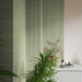 Close-up of Gallery 3D Fluted Decor Tansy Green Matt 5cm x 20cm wall tiles, showcasing the raised linear texture and soft green tone, styled with lush greenery and neutral bathroom finishes.