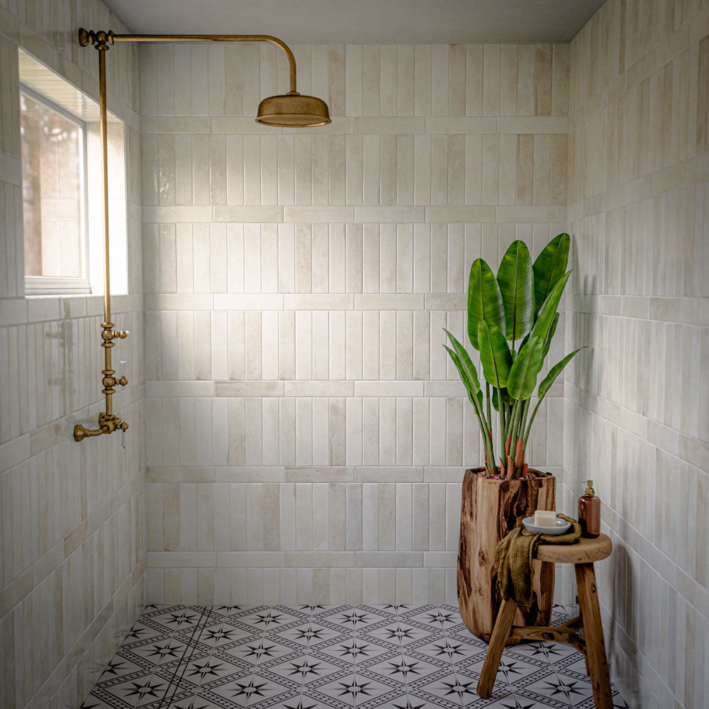 Bathroom featuring Gilgamesh Vintage White Moroccan style floor tiles, combining a classic black and white geometric pattern with decorative star motifs for a timeless statement underfoot. Paired with soft white wall tiles, warm brass shower fittings and natural wood accents, the design balances traditional character with a bright, contemporary feel, making the space both elegant and inviting.