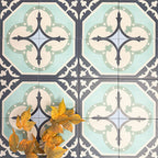 Group of London Streets Goodwin Court 20x20cm Victorian Moroccan style porcelain tiles arranged to showcase the repeating soft blue, cream and charcoal geometric pattern, styled with autumn leaves in a decorative flat-lay setting.