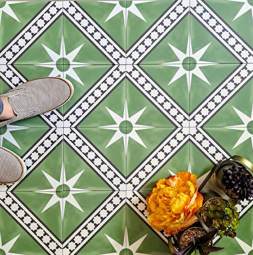 Gilgamesh Green Moroccan style 20x20cm patterned tiles, shown in a flat lay with decorative accessories highlighting the green, black and white geometric star design.