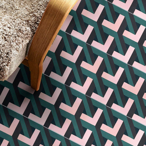 Abstract Lagoon Patterned Tiles in a 20x20cm format, laid in a repeating geometric zigzag pattern to create a bold, contemporary floor design. Deep teal, soft pink and charcoal tones add depth and contrast, styled with a wooden chair to showcase the tiles in a modern interior setting suitable for floors or feature areas.