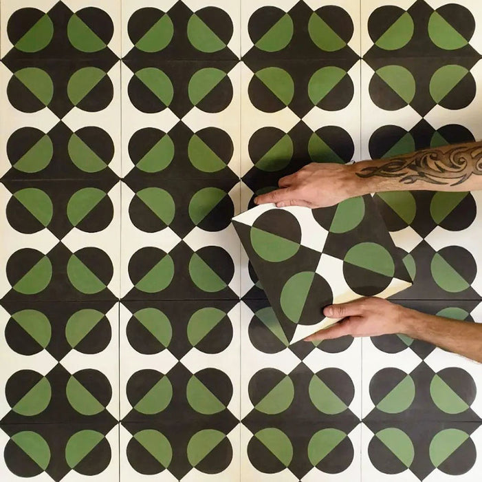 Abstract Illusion Verde Noir Patterned Tiles in a 20x20cm format, displayed in a repeated grid layout to highlight the bold optical illusion design. Deep black and rich green curved shapes create a striking, high-contrast geometric pattern, shown during installation to demonstrate how the design aligns and repeats across floors or feature walls.