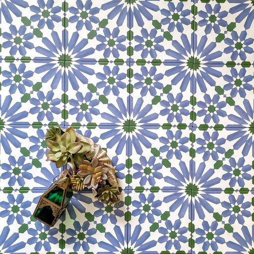 Fez Ocean Blue 20x20cm Moroccan-style porcelain wall tiles arranged in a repeating geometric pattern, featuring blue, white and green star motifs, styled with decorative succulents and a small lantern for a fresh, Mediterranean-inspired look.