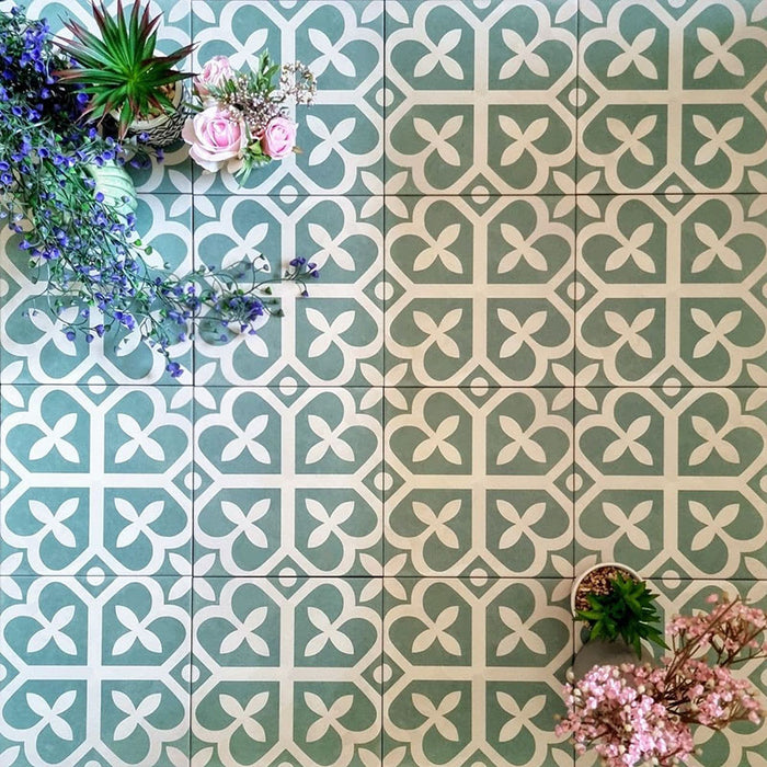 Ivy Green Victorian Moroccan style 20x20cm patterned tiles, shown in a flat lay with decorative plants highlighting the geometric design.