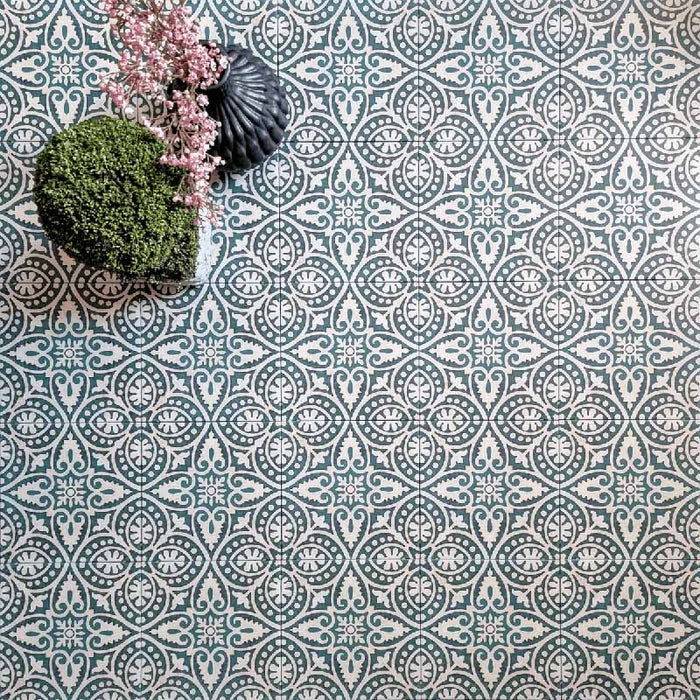 Cuba Fleur de Lis Moroccan-style porcelain tiles in a 20×20cm square format, arranged in a repeating decorative pattern featuring soft green and white detailing, styled with floral accessories to highlight the tile’s intricate motifs and classic encaustic-style design.