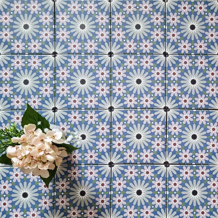 Fez Mini Artisan 15x15cm Moroccan-style porcelain wall tiles arranged in a repeating geometric pattern, featuring soft blue, blush pink, green and terracotta star motifs, styled with pale floral accents for a decorative, characterful finish.
