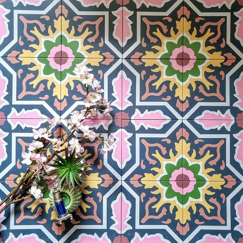 Decorative interior featuring Cuba Havana Moroccan-style porcelain tiles in a 20×20cm square format, showcasing a bold geometric pattern in navy, pink, green and mustard tones, styled with floral accessories to highlight the tile’s vibrant, vintage-inspired design.