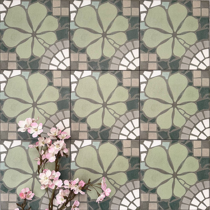 Nantes Green Moroccan-style patterned tiles in a 20x20cm format, arranged in a repeating grid to showcase the full design. The soft green floral motif is paired with mosaic-effect detailing in muted greys, creams and white, styled with delicate pink blossom accents to highlight the decorative, vintage-inspired pattern.