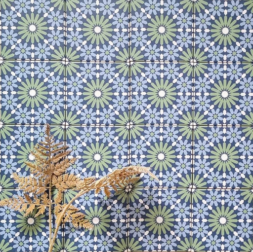 Fez Mini Springs 15x15cm Moroccan-style porcelain wall tiles arranged in a repeating geometric pattern, featuring layered blue and soft green star motifs, styled with dried foliage for a natural, decorative finish.