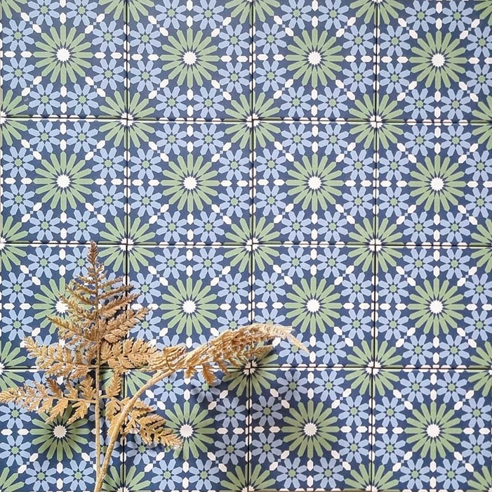 Fez Mini Springs 15x15cm Moroccan-style porcelain wall tiles arranged in a repeating geometric pattern, featuring layered blue and soft green star motifs, styled with dried foliage for a natural, decorative finish.