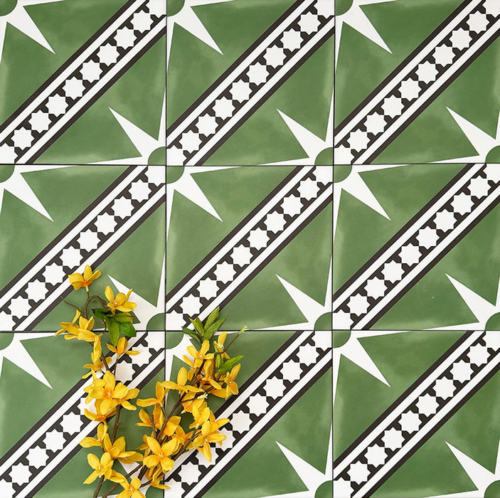 Gilgamesh Green Moroccan style 20x20cm patterned tiles, shown in a flat lay with decorative accessories highlighting the green, black and white geometric star design.