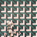 Abstract Lagoon Patterned Tiles in a 20x20cm format, displayed in a repeated grid layout to highlight the bold geometric zigzag design. Deep teal, soft pink and charcoal tones create a striking, contemporary pattern, styled with floral accents to showcase the tiles as a decorative feature suitable for walls, floors or splashbacks.