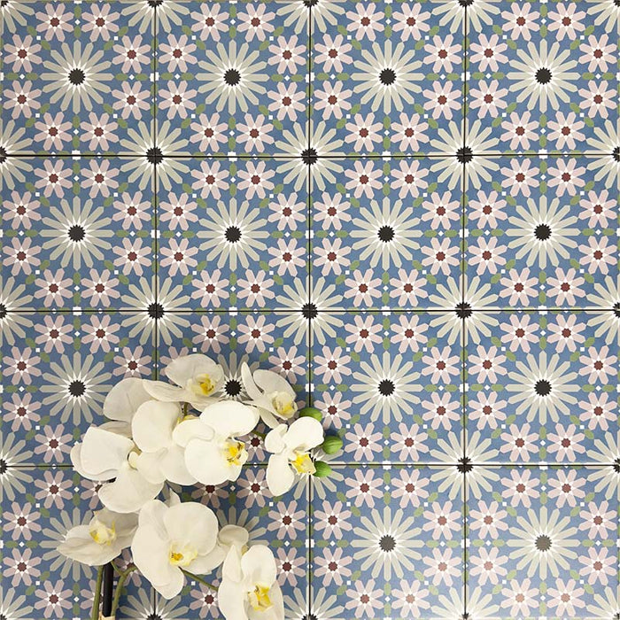 Fez Mini Artisan 15x15cm Moroccan-style porcelain wall tiles arranged in a repeating geometric pattern, featuring soft blue, blush pink, green and terracotta star motifs, styled with pale floral accents for a decorative, characterful finish.