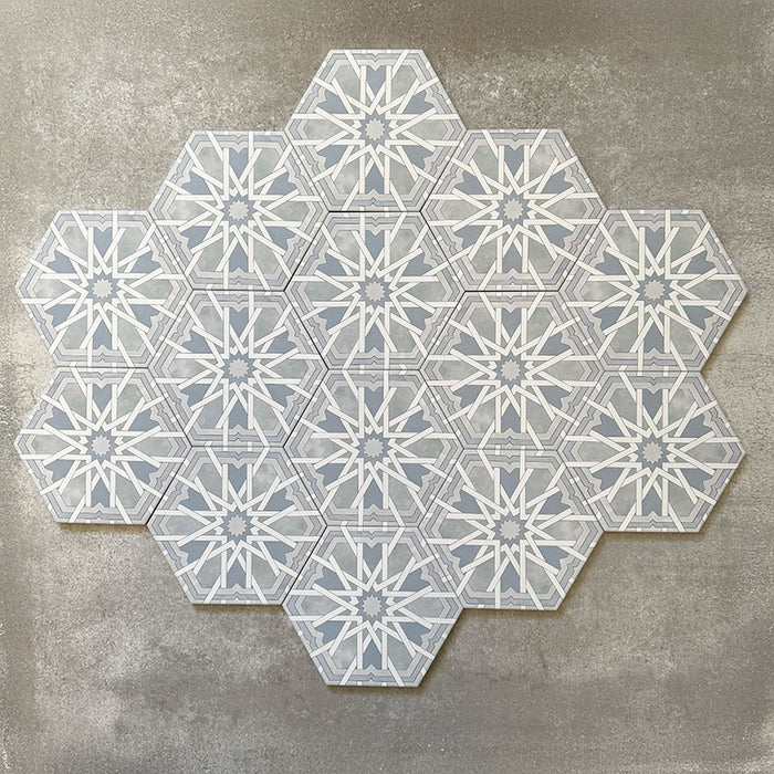 Grouped layout of Medina Hormuz Azure Blue Moroccan-style hexagon porcelain tiles, 18.7 × 21.6 cm, showcasing the full repeating star-inspired geometric pattern in soft blue and white tones on a neutral background.