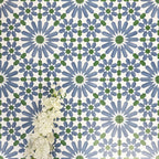 Fez Ocean Blue 20x20cm Moroccan-style porcelain wall tiles arranged in a repeating geometric pattern, featuring blue, white and green star motifs, styled with white floral accents for a fresh, decorative finish.