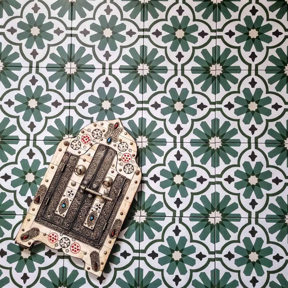 Clara Verde Victorian Moroccan-style porcelain floor tiles in a 20 × 20cm format, laid in a repeating pattern to highlight the bold green geometric design with decorative styling accents.