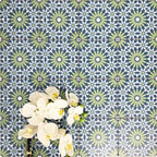 Fez Mini Springs 15x15cm Moroccan-style porcelain wall tiles arranged in a repeating geometric pattern, featuring layered blue and soft green star motifs, styled with white orchid flowers for a fresh, decorative finish.