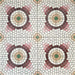 Cuba La Calle Moroccan-style porcelain tiles in a 20×20cm square format, arranged in a full repeating layout to showcase the circular mosaic-style pattern in soft white, terracotta, burgundy and green tones, highlighting the tile’s intricate detailing and classic encaustic-style design.