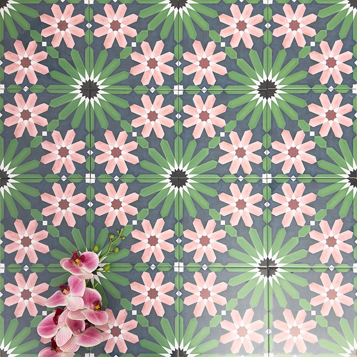 Group installation of Fez Autumn 20x20cm Moroccan-style porcelain tiles, featuring a repeating geometric floral pattern in deep green, charcoal and soft blush pink tones, styled with floral accents to highlight the encaustic-inspired design and decorative impact.