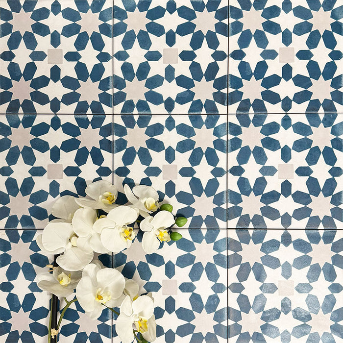 Souk Blue C 20×20cm Moroccan-style porcelain tiles arranged in a blue, white and grey geometric pattern.